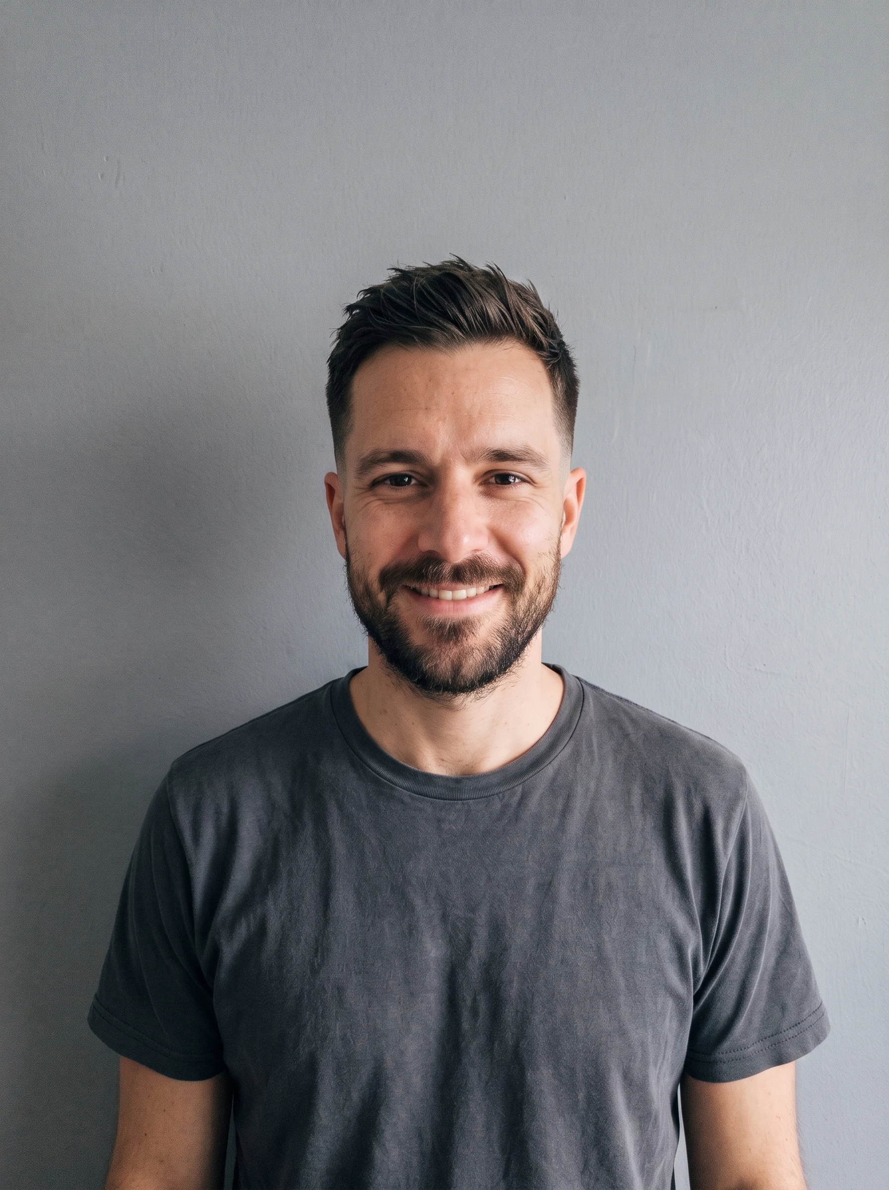 The same man with a short tapered haircut and faded sides, beard and face unchanged