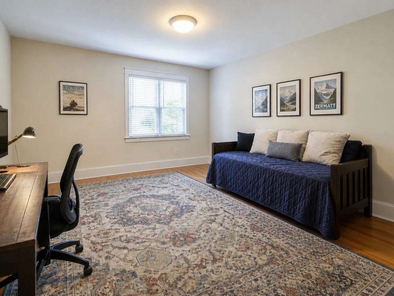 The same bedroom with the crate, ramp, bike and boxes removed while the rug and framed art remain
