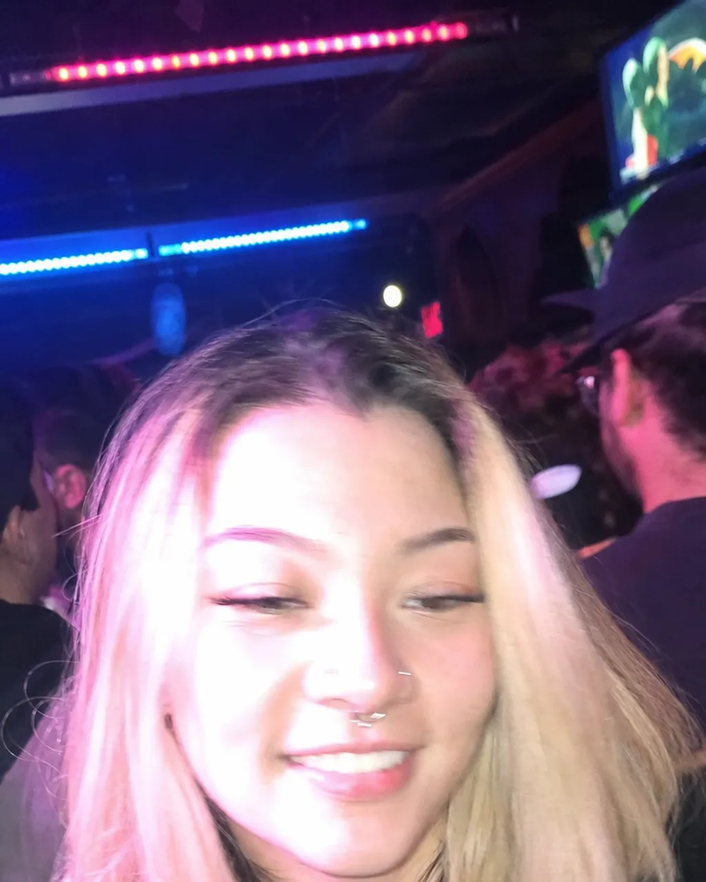 Overexposed phone photo taken in a bar under magenta LED lighting before AI dating photo generation