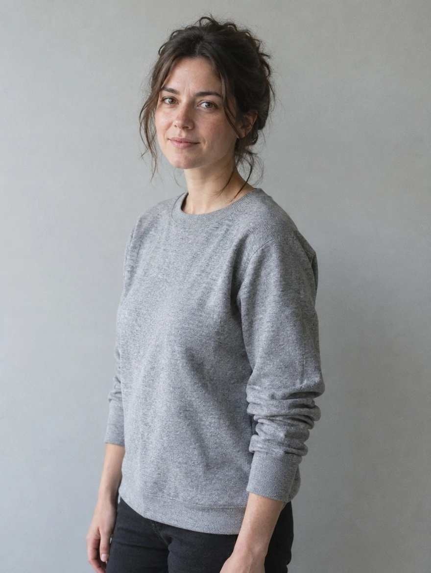 Woman in a grey crewneck sweatshirt against a studio wall, before the GPT Image 2.5 outfit edit