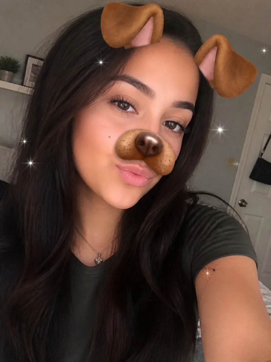 Selfie with Snapchat dog ears filter — cartoon ears, dog nose graphic and sparkle stickers on the face